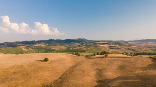 An aerial view of the Tuscany fields located in Italy seen on a beautiful sunny day