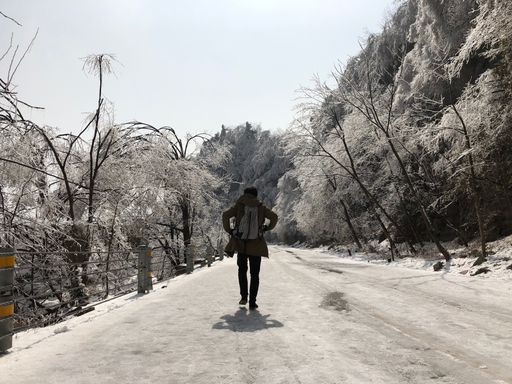 A dark shot of a man walking on a path in Zhangjiajie National Park, Cina in winter