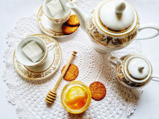 A top view of a vintage tea set with honey and biscuits