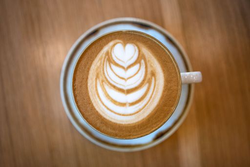 A top view of fresh cappuccino on a wooden table
