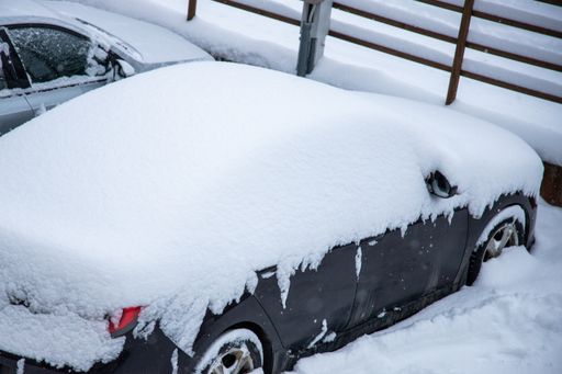 A  shot of snow-covered automobiles on a cold frozen day in winter