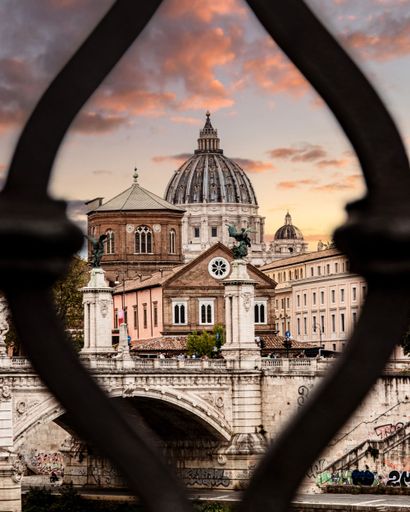 The vertical view from a fence to the St. Peter's Basilica at sunset