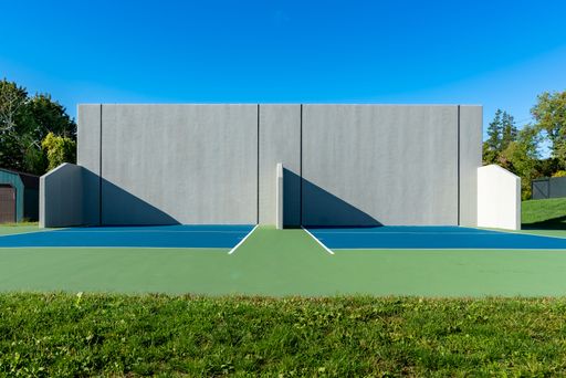Example of an outside American Handball courts with concrete wall, located at a park or school.