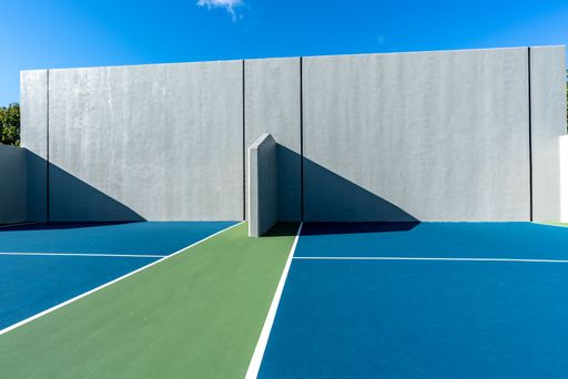 Example of an outside American Handball courts with concrete wall, located at a park or school.