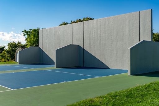 Example of an outside American Handball courts with concrete wall, located at a park or school.