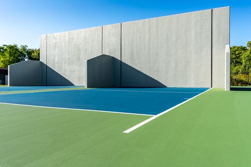 Example of an outside American Handball courts with concrete wall, located at a park or school.