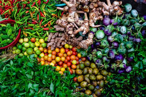 A high angle shot of bright colorful fresh vegetables on sale at a market