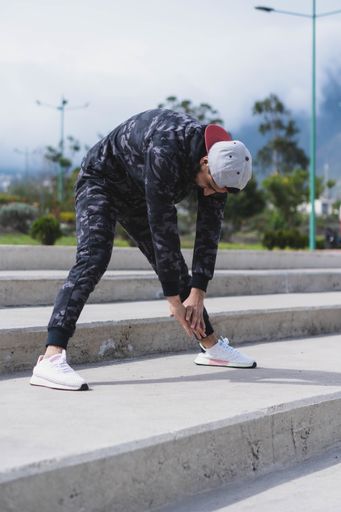 A vertical shot of a young male exercising and stretching outdoors