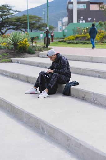 A vertical shot of a young male getting ready to work out outdoors
