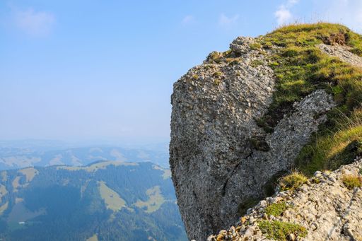 An aerial shot of a mountain peak, revealing the picturesque valley below