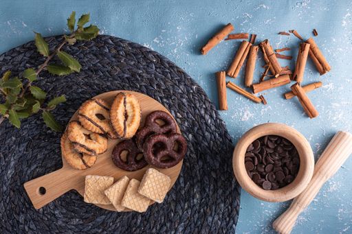 A top view of assorted biscuits on a wooden platter with cinnamon roll