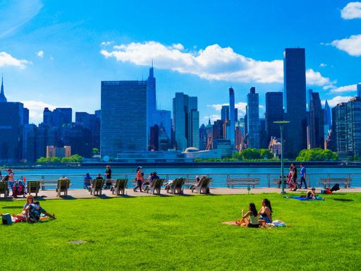 People enjoying their time at Gantry Plaza State Park in Long Island City, NY on a beautiful bright day