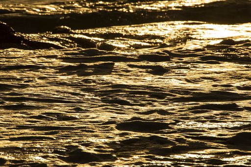 A mesmerizing view of the waves forming in the sea on a gloomy and windy day during the sunset