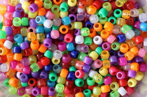 A shot of multi-colored plastic beads for handicrafts scattered on the table