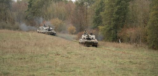 The military tanks moving in a field