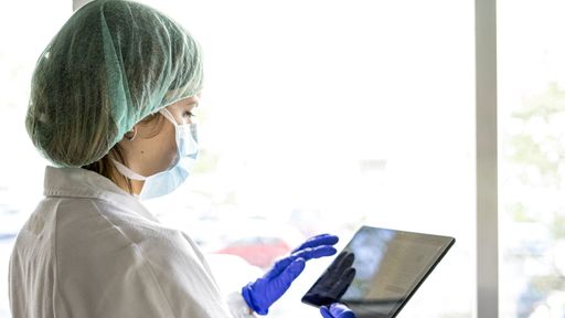 A shallow focus closeup of a female medical practitioner using a smartphone in the hospital