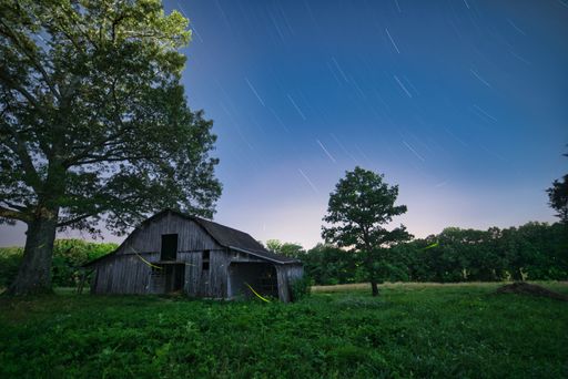 A closeup view of an old wooden barn in the middle of field