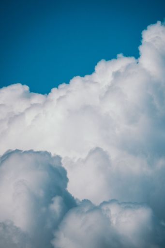 A vertical shot of the clean sky with clouds during daytime