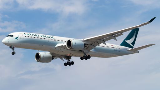A Cathay Pacific Airlines aircraft soaring against a blue sky backdrop.