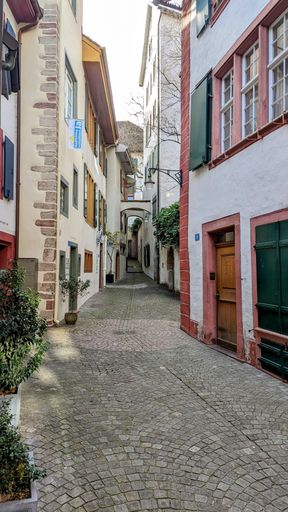 A vertical shot of a long narrow street between the buildings in a town in switzerland