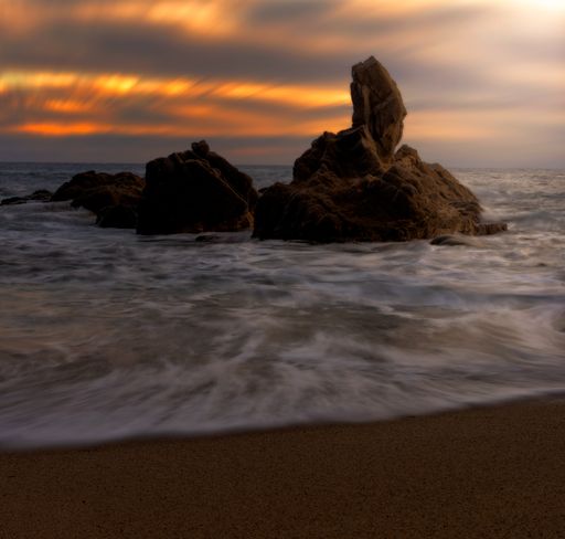 A beautiful shot of a beautiful colorful sunrise on the shore of Cala del Paller in Spain