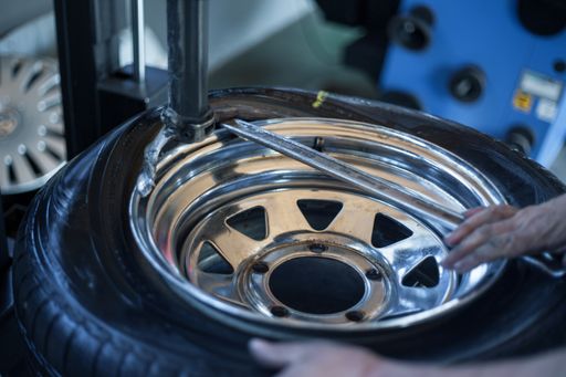 A selective focus shot of a mechanic repairing a car wheel