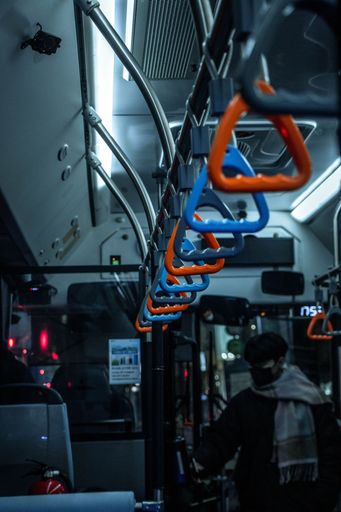 A vertical shot of the colorful handrails in the bus