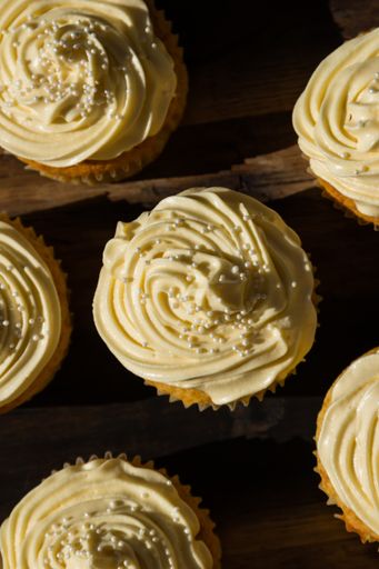 A high angle shot of cupcake desserts on a wooden surface