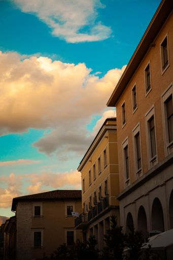 A vertical low angle shot of city buildings during a golden sunset