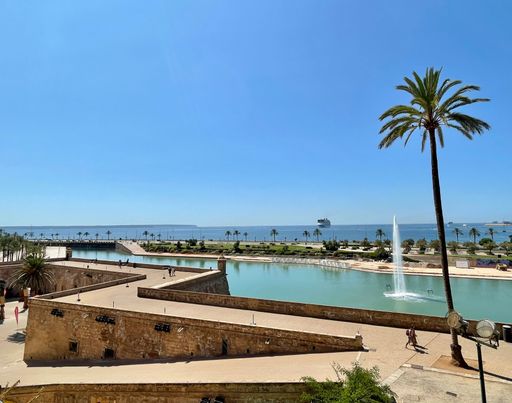 A scenic view of a hotel in the shore of the sea during daytime on a summer day