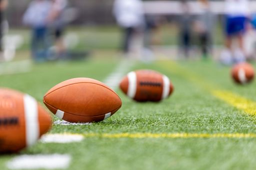 The multiple American Football balls laying on a training field