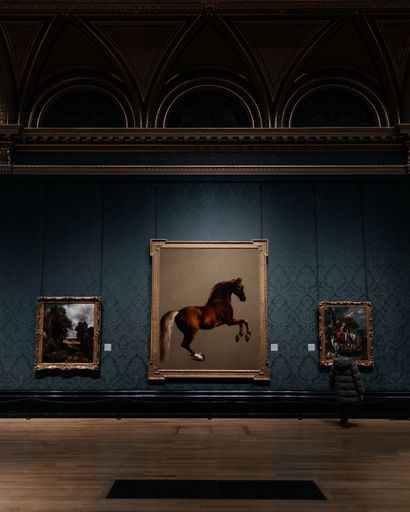 A woman is appreciating the artwork of a horse in the Sackler Room of the National Gallery