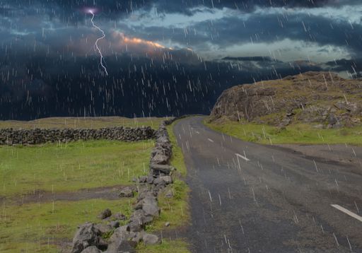 A road in a field covered in rocks and grass during the thunderstorm in the Irish