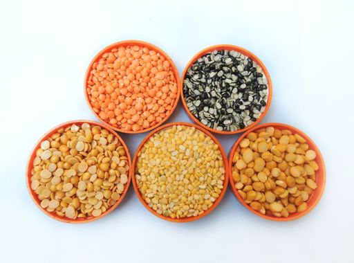 A top view of bowls of different lentils like mung beans, chickpea lentils and pigeon peas