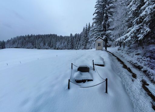 An aerial view of tombstones in a snow covered field near a forest in Slovenia