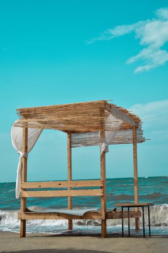 A vertical shot of a wooden deck chair next to the sea on a sunny day in Chalkidiki, Greece