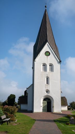 A vertical shot of the Nebel St.-Clemens-Kirche under a blue sky in Amrum, Germany
