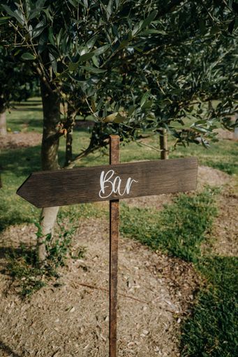 A close-up shot of a wooden board showing the direction to the bar
