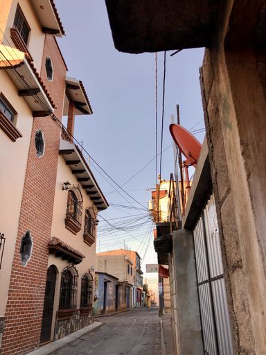 A vertical shot of an alley of residential buildings under the sunlight at daytime