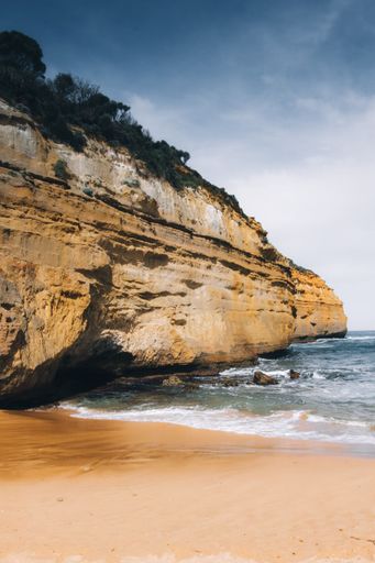 The Loch Ard Gorge surrounded by the sea under a cloudy sky in Australia