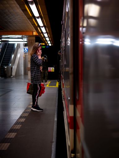 A vertical shot of a girl in a mask waiting for a metro in the subway station in Prague.