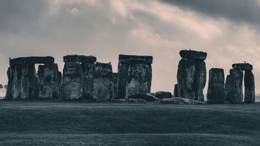A landscape scene of Stonehenge monument in England under dramatic cloudy sky