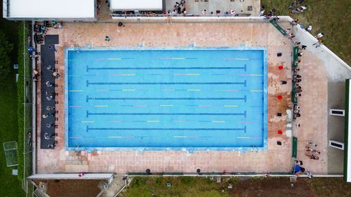 A top view of participants ready to jump in a clear blue pool