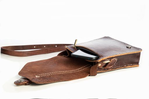 A closeup of a dark brown leather bag for men isolated on a white background