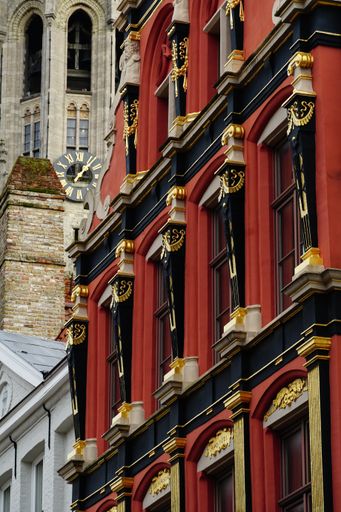 A vertical shot of an interesting and unique red facade of a building in old Town Bruges, Belgium