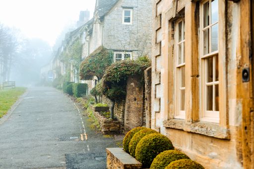 A beautiful shot of old houses along a narrow street on a foggy day in Burford, Cotswolds, Oxfordshire, England