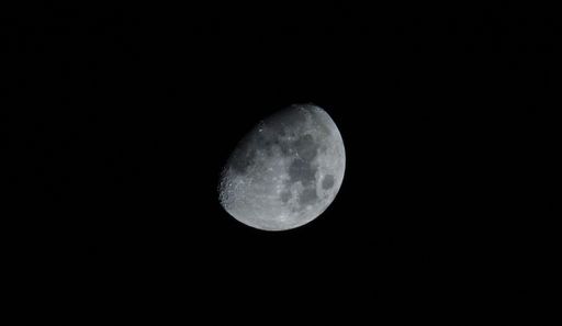 A stunning image of a crescent moon illuminated in a starry night sky, set against a deep black backdrop
