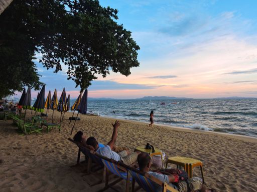 Tourists relaxing and enjoying the beautiful sunset in Jomtien Beach, Pattaya.