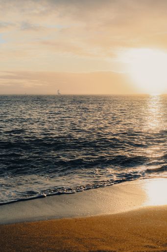 A vertical shot of a dreamy sunset over the calm sea