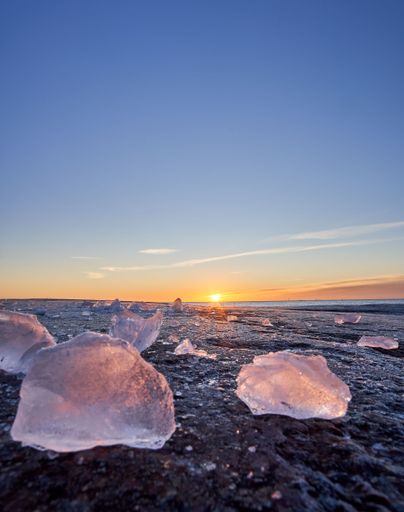 A vertical shot of crystals on the beach at sunset